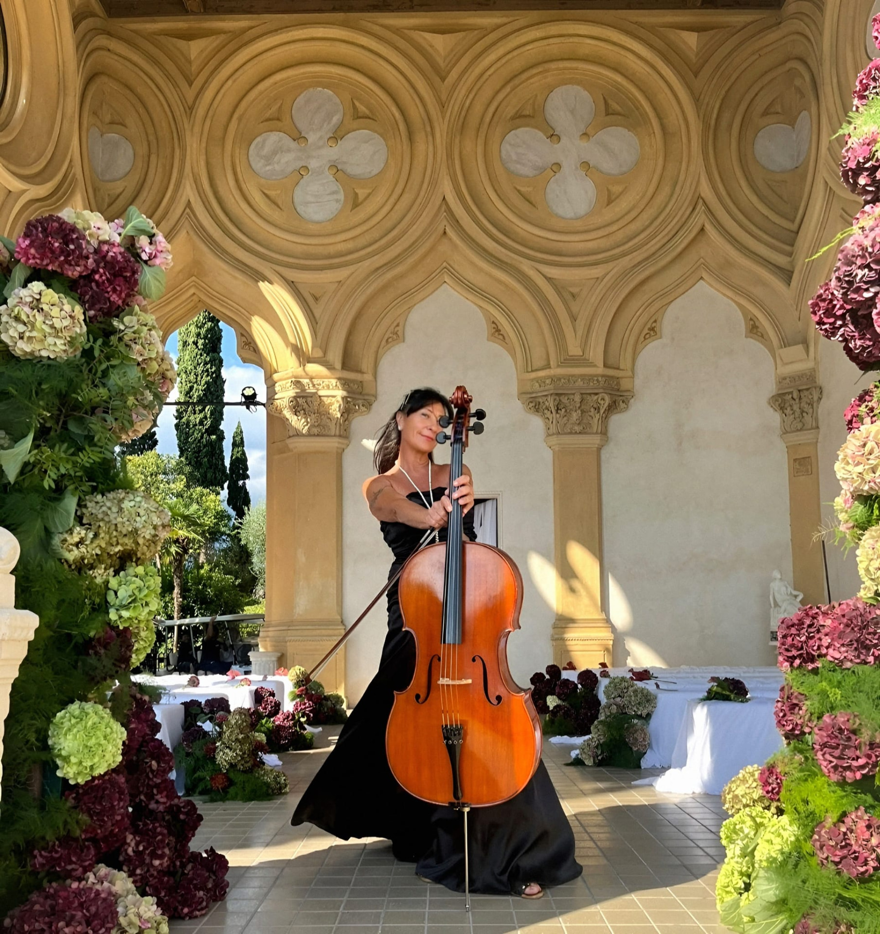 Ilaria Giorgi al violoncello nella loggia fiorita di una location per matrimoni